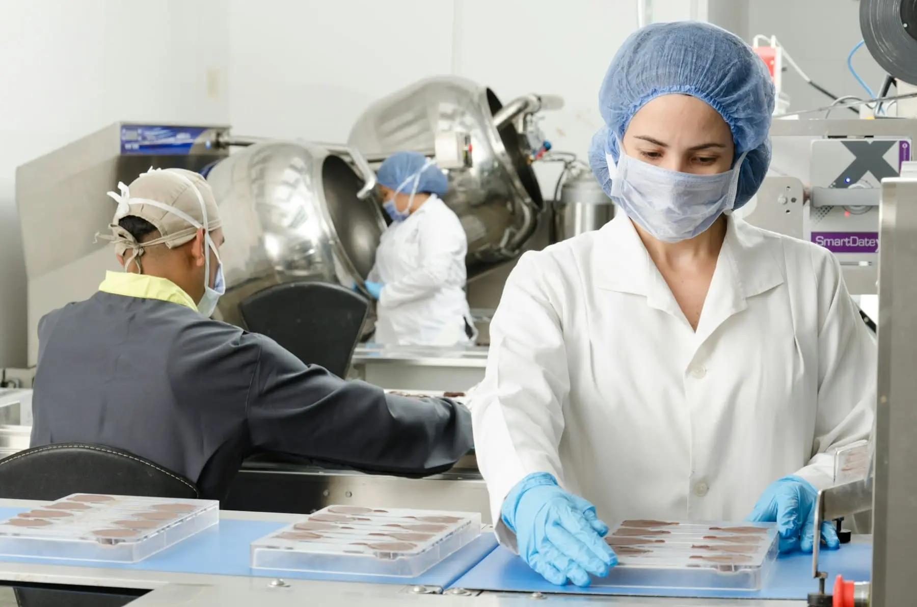 Workers in protective clothing inside a production facility